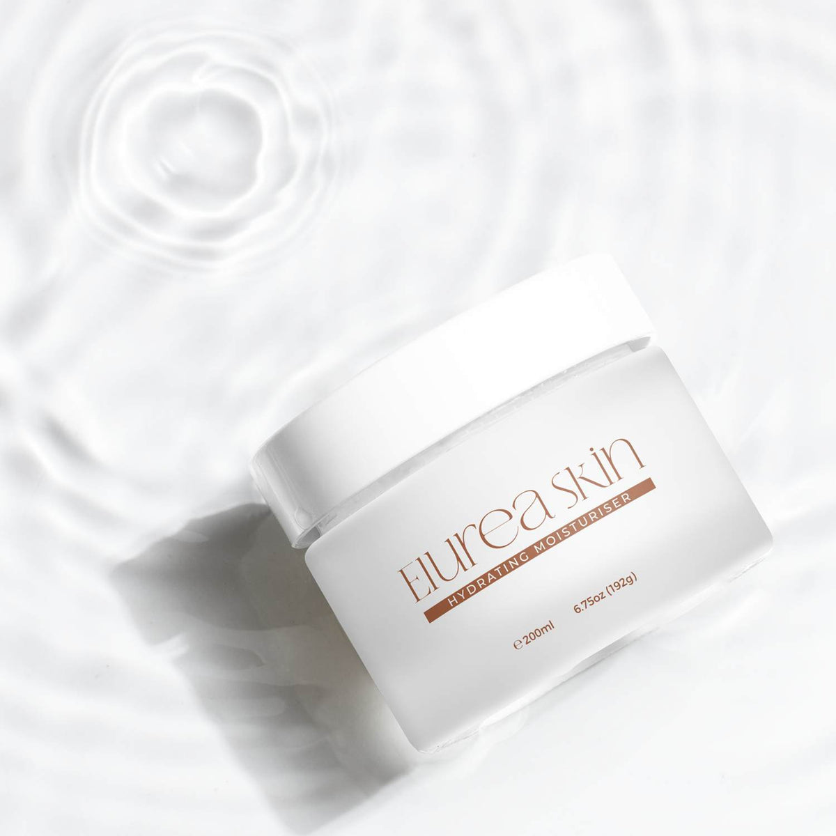 White frosted cosmetic jar with a white lid and brown printed design, resting in clear rippling water