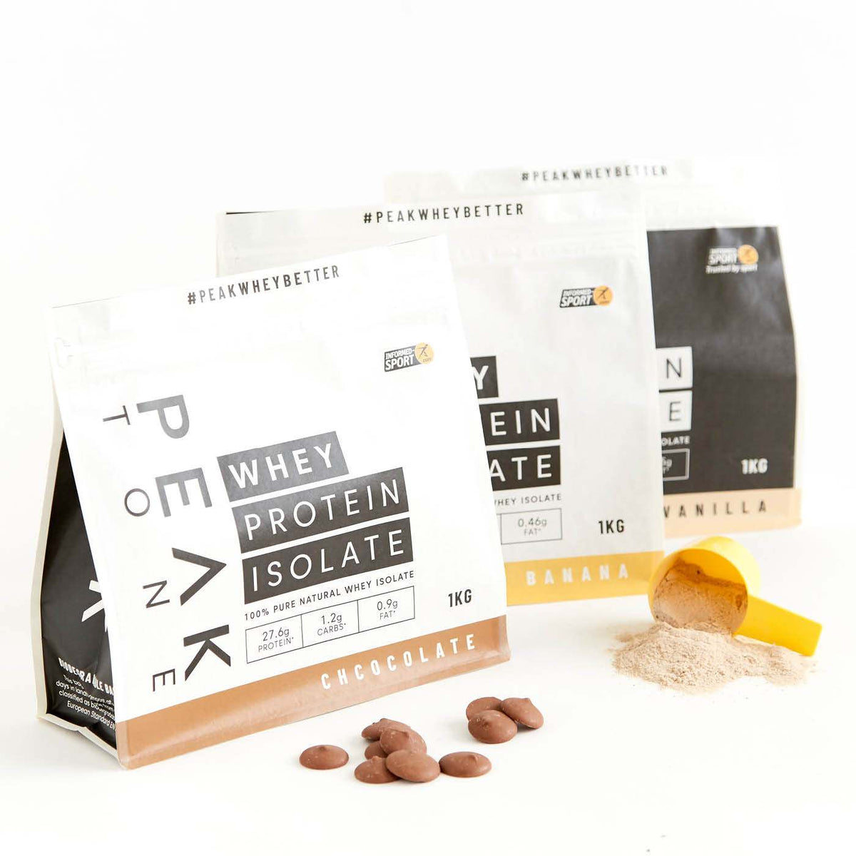 Custom printed matte white and black pouches with chocolate pieces and a powder scoop on a white surface