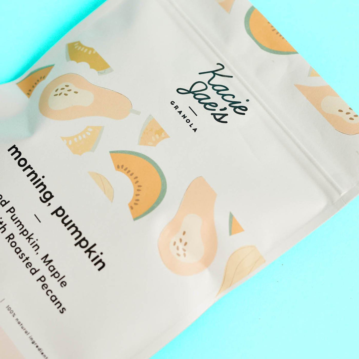 Matte white stand-up pouch printed with pastel pumpkin illustrations on a bright aqua background