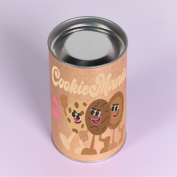 Kraft packaging cylinder with a silver metal lid and cartoon cookie print on a pale purple background
