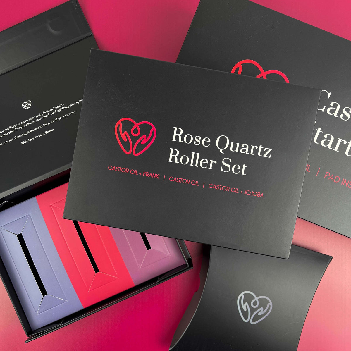 Matte black packaging boxes with custom pink print, colourful inner slots and a pillow box on a pink background