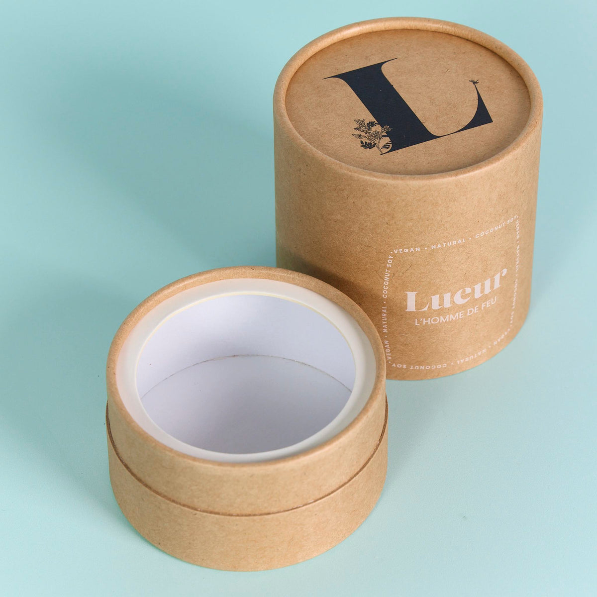 Open brown kraft cylinder packaging with custom print and a white interior on a light blue background