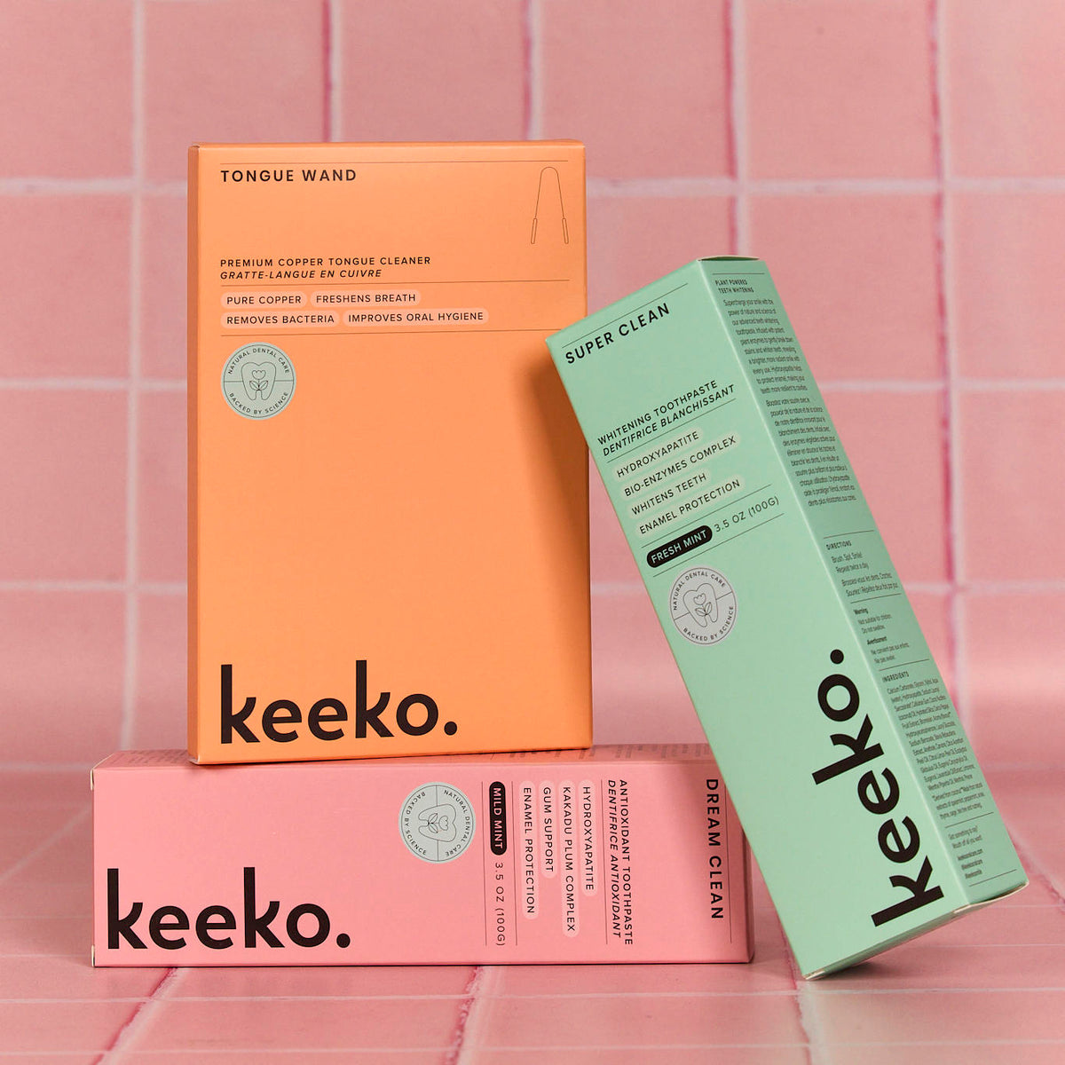 Peach, pink and mint green custom-printed retail cartons against a pink tiled background