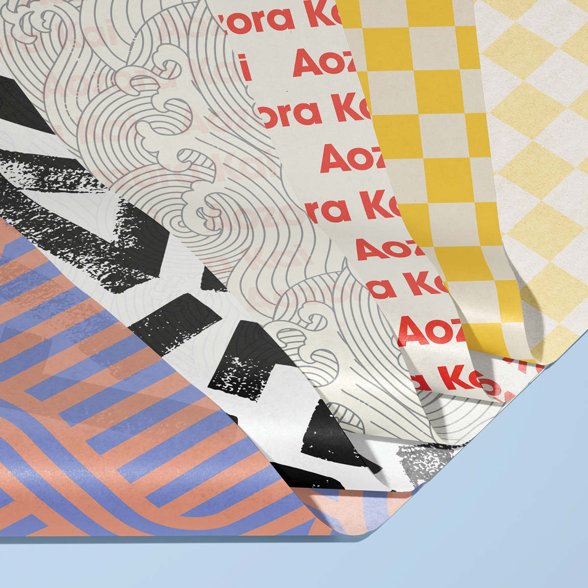 Printed tissue paper sheets in various colourful patterns fanned out against a light blue background