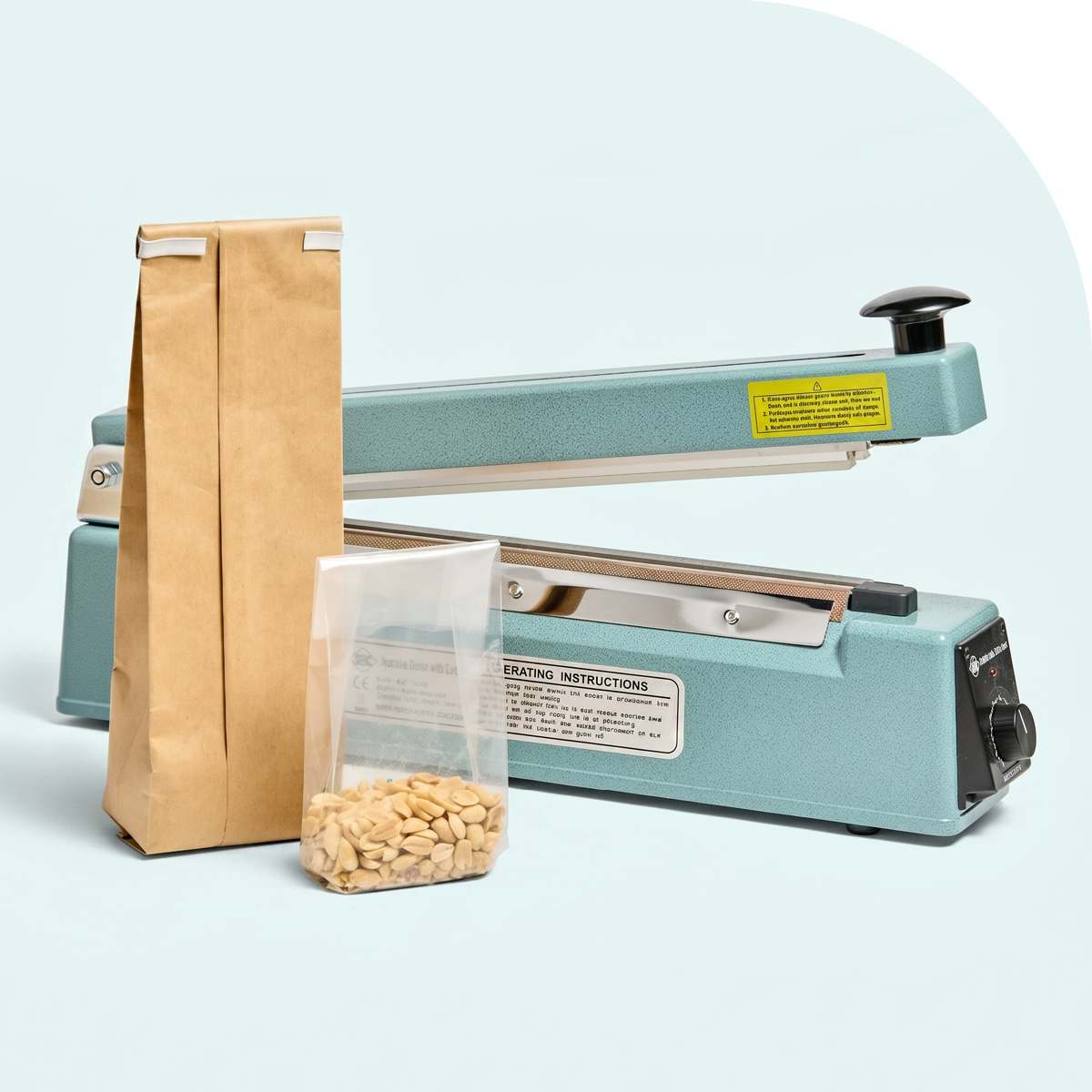 A teal impulse heat sealer beside a tall kraft paper bag and a clear plastic bag filled with peanuts