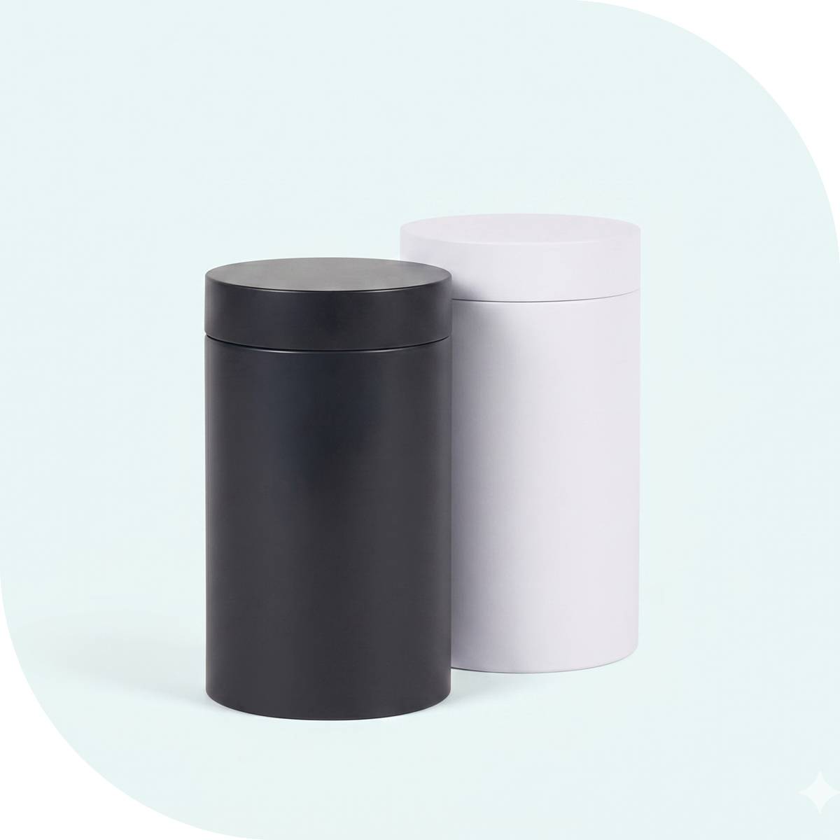 Plain matte black and white packaging cylinders with lids on a light background