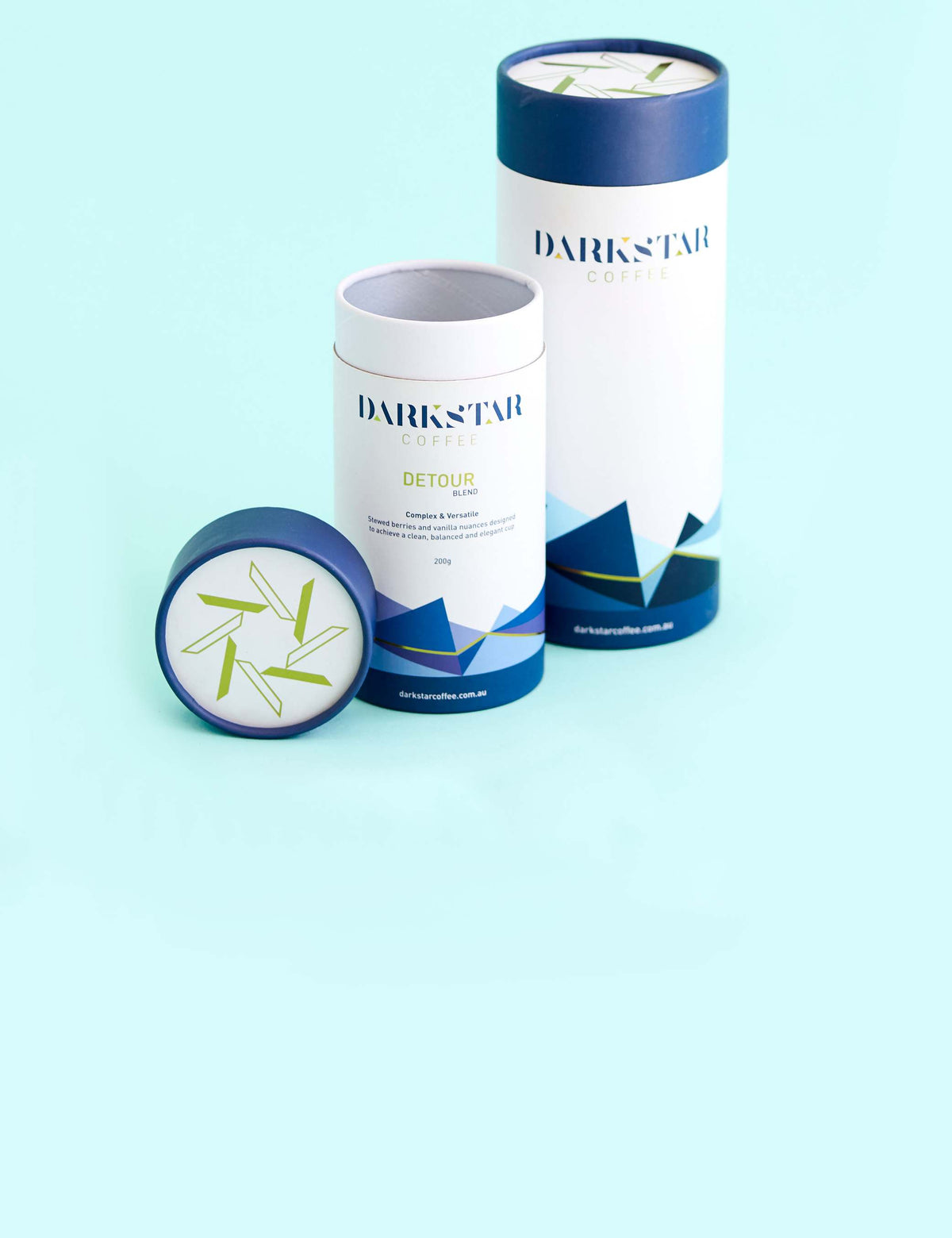 Custom-printed white and blue cardboard packaging cylinders with lids on a light blue background